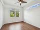 Bedroom with ceiling fan, hardwood floors, and natural light, offering a bright and cozy ambiance at 511 Roanoke St, Dunedin, FL 34698