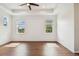 A bright and airy bedroom showcasing hardwood floors and natural light from multiple windows at 511 Roanoke St, Dunedin, FL 34698