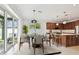 Dining area with a view of the backyard through sliding glass doors, next to an island kitchen at 511 Roanoke St, Dunedin, FL 34698