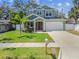 Charming two-story home with fresh landscaping, a manicured lawn, a two-car garage, and a welcoming front porch at 511 Roanoke St, Dunedin, FL 34698
