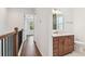 Hallway featuring beautiful hardwood floors leading to the bathroom, with a wood staircase railing at 511 Roanoke St, Dunedin, FL 34698