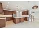 Spacious kitchen with an island, stainless steel appliances, and dark wood cabinets next to a staircase at 511 Roanoke St, Dunedin, FL 34698