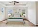 A stylish bedroom with a tray ceiling, ceiling fan, and large windows, and neutral décor at 511 Roanoke St, Dunedin, FL 34698