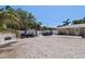 Gravel backyard area with trailer and ATV parking behind a white fence at 5201 108Th N St, St Petersburg, FL 33708