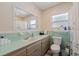 Bathroom with tile countertops and walls, updated vanity, ample lighting, and a toilet at 5201 108Th N St, St Petersburg, FL 33708