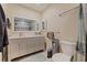 Bright bathroom with double vanity, tile flooring, large mirror, and tiled shower and bathtub at 5201 108Th N St, St Petersburg, FL 33708