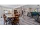 Open-concept dining room with hardwood flooring, wood table and chairs, flowing into the living room and kitchen at 5201 108Th N St, St Petersburg, FL 33708