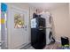Laundry room with stacked washer/dryer, retro mini fridge, and access to the backyard at 5201 108Th N St, St Petersburg, FL 33708
