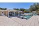 Outdoor pool and patio area with covered seating and a well-manicured yard at 5201 108Th N St, St Petersburg, FL 33708