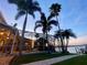 Backyard boasts a screened enclosure, inviting pool, waterfront view, and palm tree landscaping at 5225 Brighton Shore Dr, Apollo Beach, FL 33572