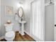 Charming bathroom with a pedestal sink, toilet, and shower featuring a white curtain at 5225 Brighton Shore Dr, Apollo Beach, FL 33572