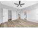 Spacious bedroom with light hardwood floors, ceiling fan, and doorways to a closet and bathroom at 5225 Brighton Shore Dr, Apollo Beach, FL 33572