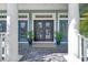 Elegant home entrance with classic columns, stylish double doors, and a welcoming front porch at 5225 Brighton Shore Dr, Apollo Beach, FL 33572