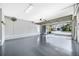 Spacious garage with epoxy flooring and an open door revealing the driveway at 5225 Brighton Shore Dr, Apollo Beach, FL 33572