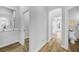Hallway with wood floors leading to an arched doorway, bathroom, and other rooms at 5225 Brighton Shore Dr, Apollo Beach, FL 33572