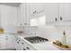 Stylish kitchen features white cabinetry, marble countertops, and a modern gas cooktop with contemporary backsplash at 5225 Brighton Shore Dr, Apollo Beach, FL 33572