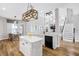 Open-concept kitchen with a central island, marble countertops, and modern appliances, connecting seamlessly to the dining area at 5225 Brighton Shore Dr, Apollo Beach, FL 33572