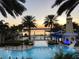 Community swimming pool featuring a water slide, lush palm trees, and waterfront views at 5225 Brighton Shore Dr, Apollo Beach, FL 33572