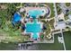 Aerial view of community pool with various lounge chairs, palm trees, and a water slide at 5225 Brighton Shore Dr, Apollo Beach, FL 33572