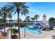 Resort-style pool area featuring a lighthouse-themed structure, slides, palm trees, and inviting lounge chairs at 5225 Brighton Shore Dr, Apollo Beach, FL 33572