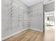 Spacious walk-in closet with custom shelving and modern wood floors at 5225 Brighton Shore Dr, Apollo Beach, FL 33572