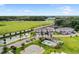 Aerial view of townhomes, pond, pool, parking lot, and landscaped green space at 5496 Riverwalk Preserve Dr, New Port Richey, FL 34653