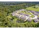 Aerial view showcases community townhomes near a pond, greenery and plenty of parking at 5496 Riverwalk Preserve Dr, New Port Richey, FL 34653