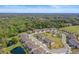 A picturesque aerial view shows townhomes, lush landscapes and a pond at 5496 Riverwalk Preserve Dr, New Port Richey, FL 34653