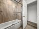 Bathroom with tub and shower combination, sliding glass door, and tile surround at 5496 Riverwalk Preserve Dr, New Port Richey, FL 34653