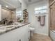 Bathroom with granite countertop, large mirror, and tiled walk-in shower at 5496 Riverwalk Preserve Dr, New Port Richey, FL 34653