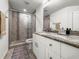Modern bathroom featuring a tiled shower with glass door and granite vanity at 5496 Riverwalk Preserve Dr, New Port Richey, FL 34653