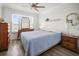 Bright bedroom with wood-look floors, ceiling fan, and window views at 5496 Riverwalk Preserve Dr, New Port Richey, FL 34653