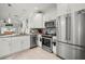 Bright kitchen featuring stainless steel appliances, granite countertops, and white cabinets at 5496 Riverwalk Preserve Dr, New Port Richey, FL 34653