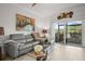 Inviting living room with comfortable seating, decorative artwork, and access to an outdoor patio at 5496 Riverwalk Preserve Dr, New Port Richey, FL 34653