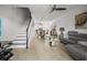 Bright and open-concept living room with modern furnishings, staircase and tile flooring at 5496 Riverwalk Preserve Dr, New Port Richey, FL 34653