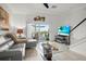 Cozy living room with a plush sofa, flat-screen TV, and sliding doors to the outdoor space at 5496 Riverwalk Preserve Dr, New Port Richey, FL 34653