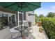 Private patio with shade umbrella and comfortable seating, surrounded by lush landscaping at 5496 Riverwalk Preserve Dr, New Port Richey, FL 34653