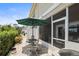 Charming outdoor patio featuring a table set with an umbrella, ideal for relaxation and entertaining at 5496 Riverwalk Preserve Dr, New Port Richey, FL 34653