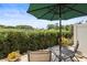 Inviting outdoor patio with table seating surrounded by lush hedges and a bright blue sky at 5496 Riverwalk Preserve Dr, New Port Richey, FL 34653