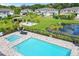 Community pool and spa surrounded by lush landscaping and lounge seating in a meticulously maintained neighborhood at 5496 Riverwalk Preserve Dr, New Port Richey, FL 34653