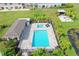 Aerial view of the community pool, spa, and clubhouse with a patio surrounded by lush tropical greenery at 5496 Riverwalk Preserve Dr, New Port Richey, FL 34653