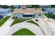 A charming single-story home with a lush, green lawn and unique driveway design from above at 5672 62Nd N Way, St Petersburg, FL 33709