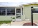 Charming front door with storm door and lovely flower pot next to the many windows at 5672 62Nd N Way, St Petersburg, FL 33709