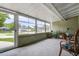Sunroom porch with windows and view to front of house with chairs and plants at 5672 62Nd N Way, St Petersburg, FL 33709