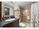 Bathroom featuring granite countertop, updated fixtures, and a well-maintained shower with floral curtains at 611 Destiny Dr # 204, Ruskin, FL 33570