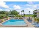 A community pool has lounge chairs and tables for residents at 611 Destiny Dr # 204, Ruskin, FL 33570