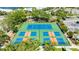 Aerial view shows tennis and pickleball courts with lush landscaping surrounding the area at 611 Destiny Dr # 204, Ruskin, FL 33570