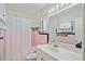 Retro bathroom featuring pink tile accents, a white vanity, and a shower with a curtain at 6132 7Th S Ave, Gulfport, FL 33707
