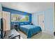 Bright bedroom featuring blue accent wall, bedside table, and a large window showcasing the outdoor scenery at 6132 7Th S Ave, Gulfport, FL 33707