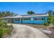 Bright blue single-story home with green shutters and solar panels on a sunny day at 6132 7Th S Ave, Gulfport, FL 33707